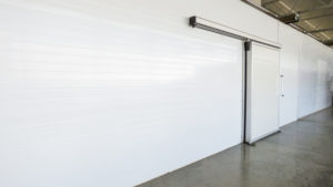 Large freezer storage in the factory. closed door from warehouse